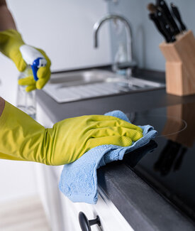 Hands wiping counter surface