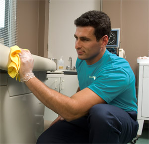 man wiping surface in hospital