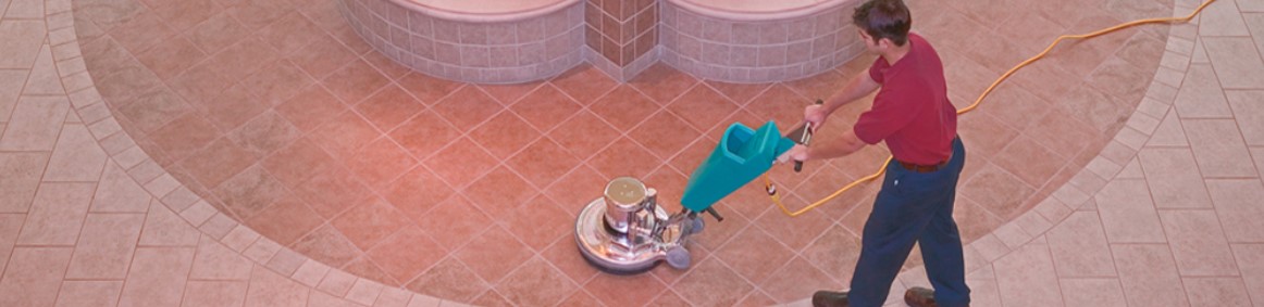 man using buffer to wax floor