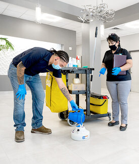 Man Pouring Cleaning Liquid into Bottle & Woman Standing Nearby